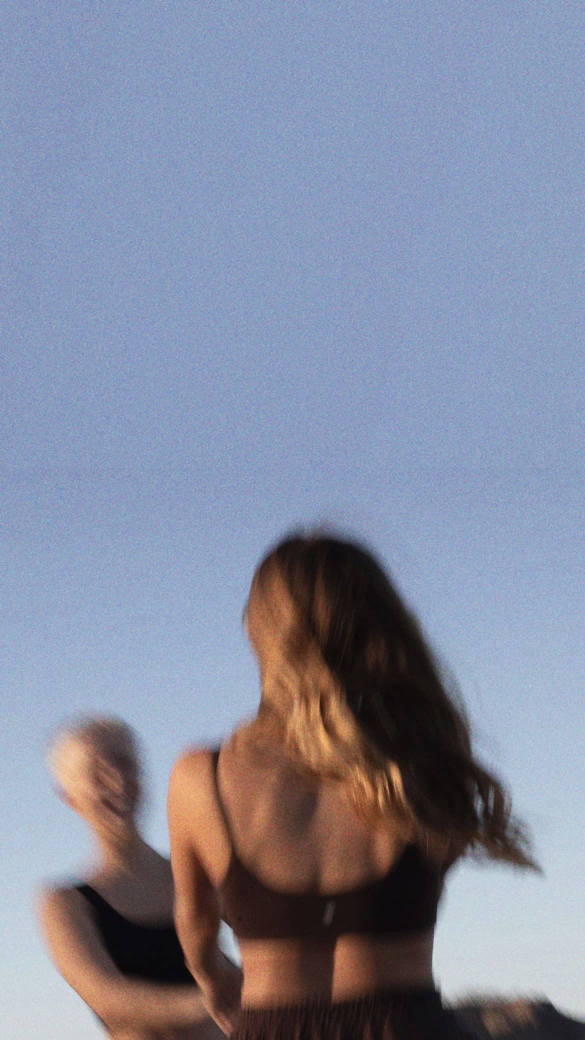 Charlotte and Katja dancing on the beach at dusk